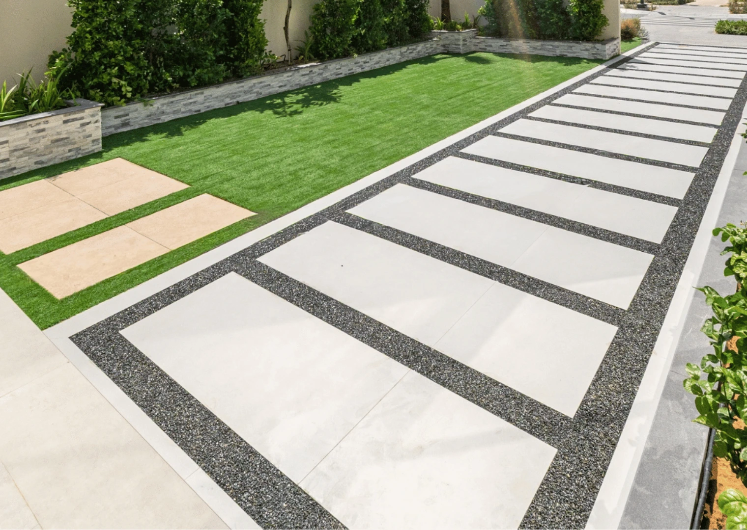 Hard landscaping in Dubai: paving slabs with gravel joints beside artificial grass